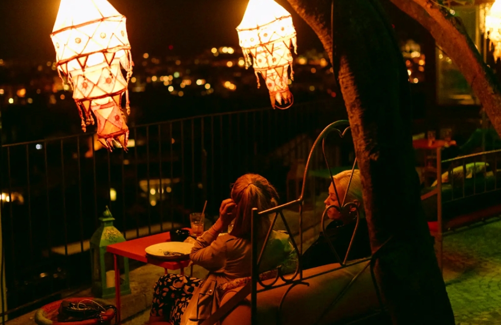 Zwei Frauen trinken einen Drink und genießen die Aussicht auf Lissabon vom Lost In