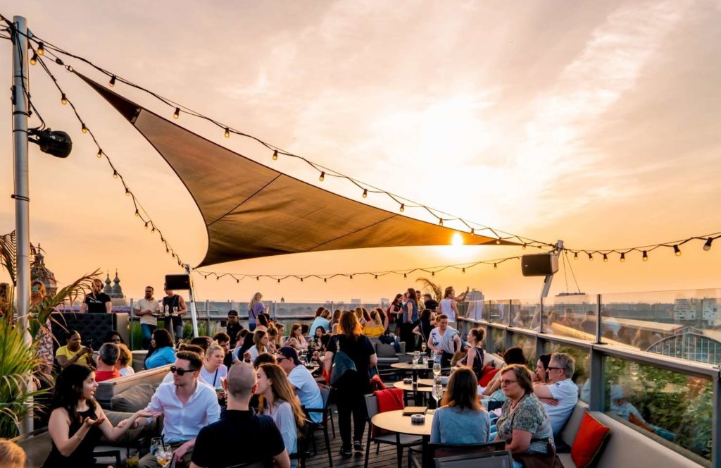 People on a teracce enjoying a glass of wine with a sunset 