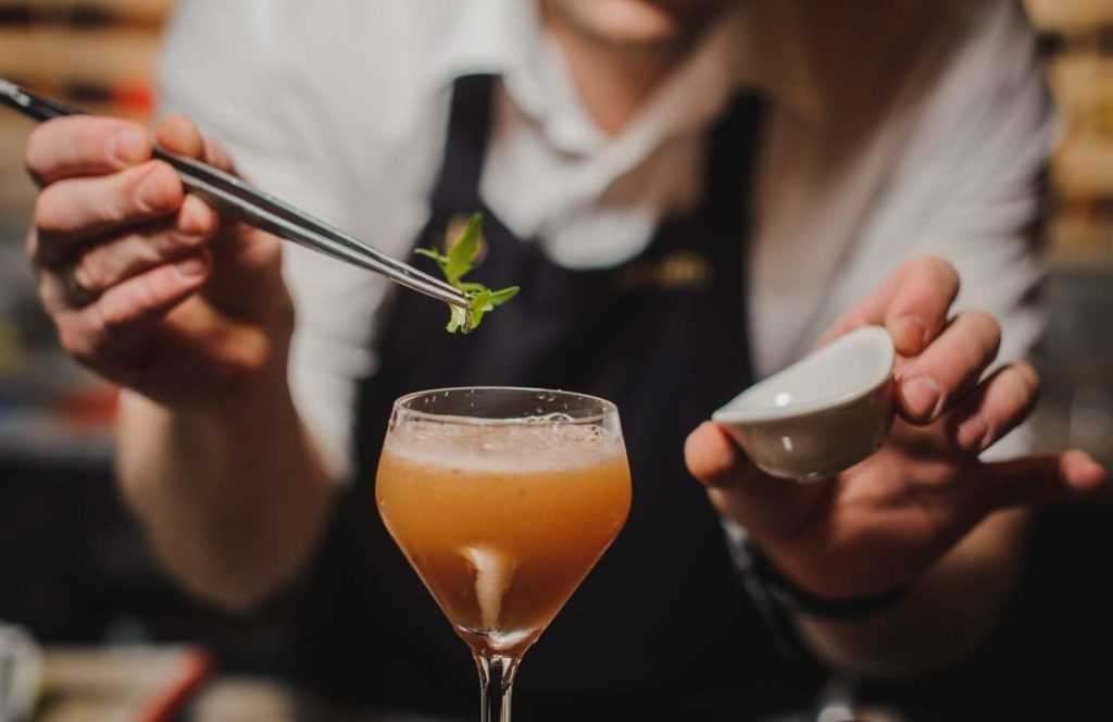 a bartender in a Lisbon speakeasy makes a cocktail