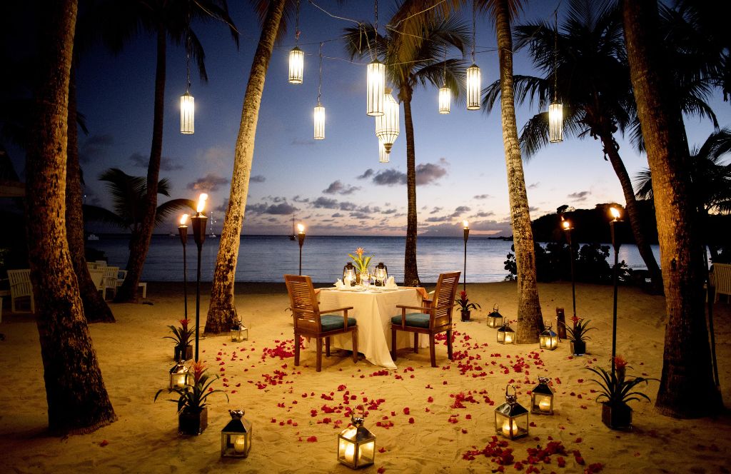 tables and chairs set up on the beach in a romantic setting in one of the most unique honeymoon destinations worldwide