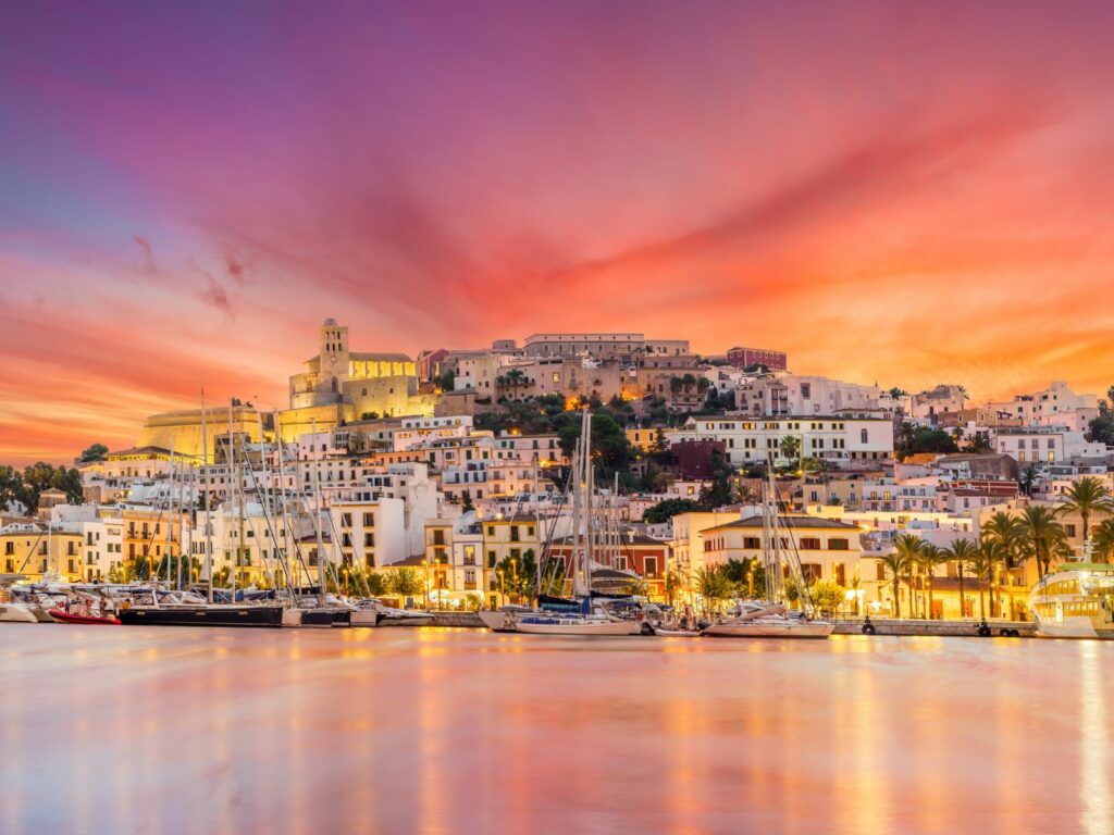the sun sets on ibiza town during a weekend in ibiza