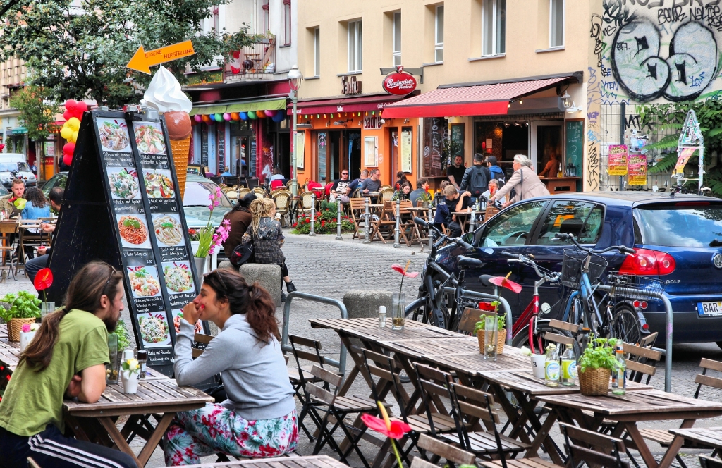 Menschen sitzen draußen in einem Café in Kreuzberg