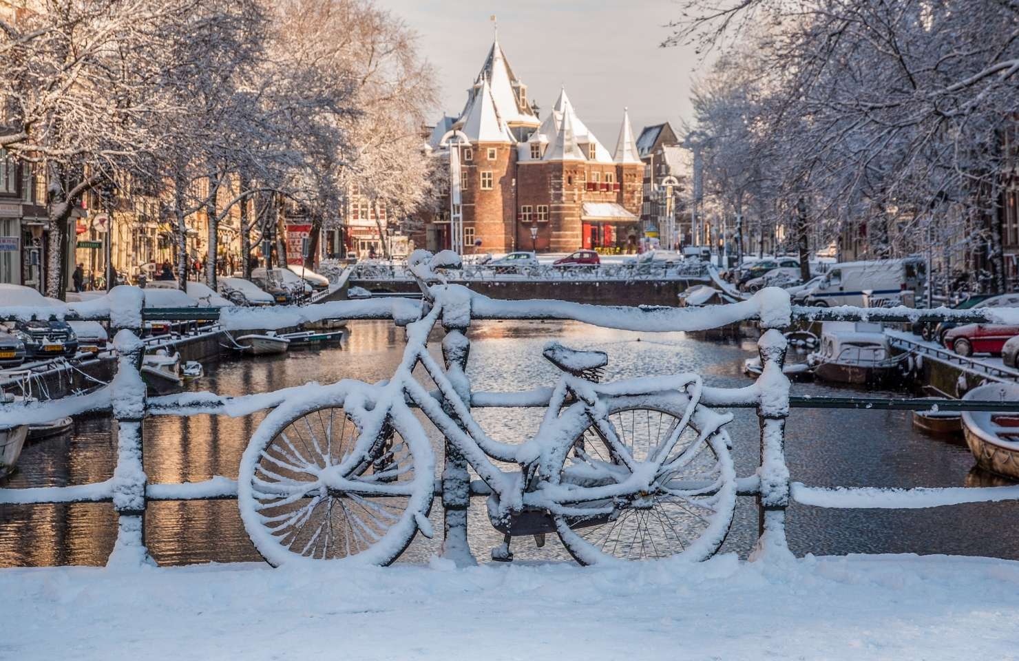 bike with snow on it in amsterdam above a canal