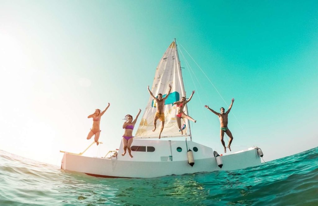jeunes en vacances entre amis à Ibiza sautant d'un bateau en mer