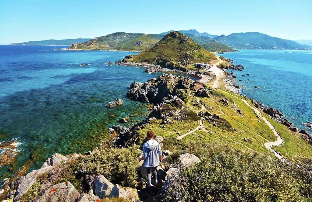 Une femme randonnant lors de ses vacances en Corse