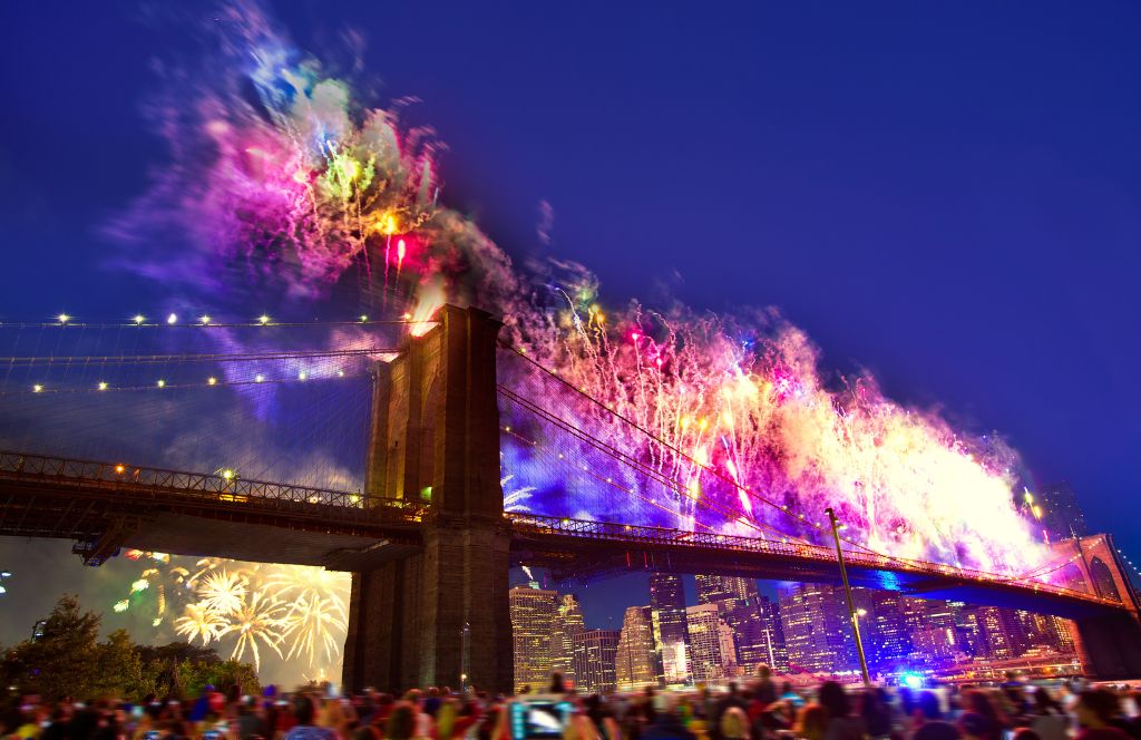 people celebrate new year in new york by watching fireworks from the brooklyn bridge