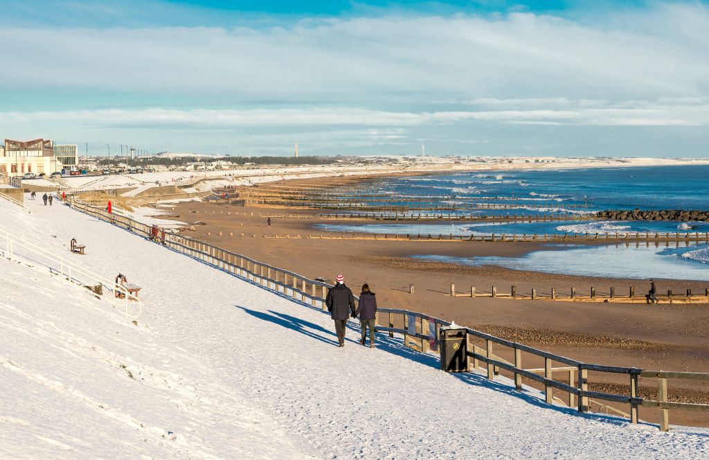 the beach in aberdeen in winter with snow - one of the best destinations for a winter holiday in the uk