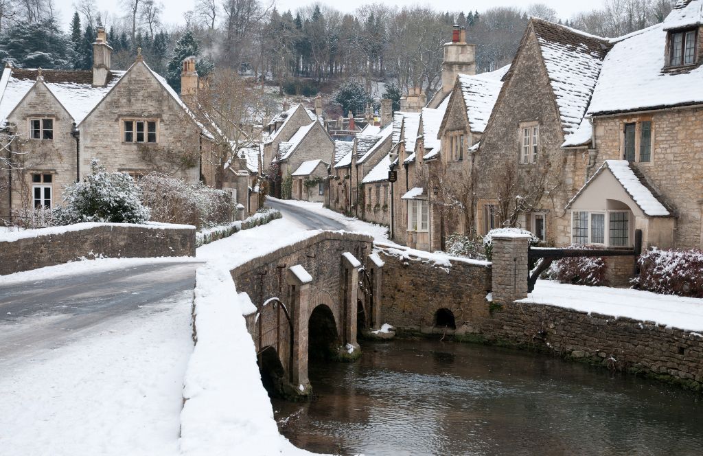 traditional stone houses in the cotswolds with snow - one of the best destinations for a winter holiday in the uk
