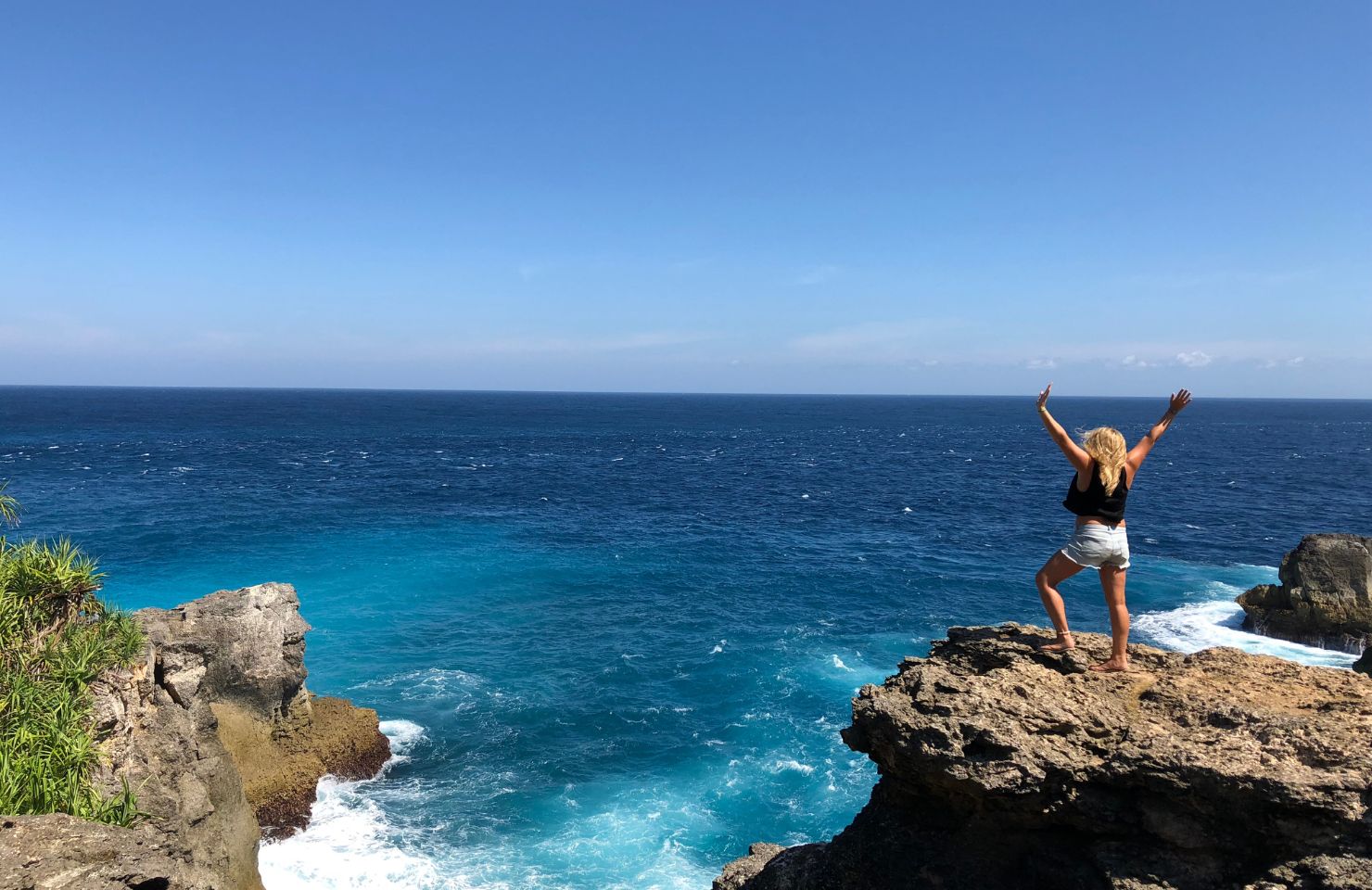 Sam steht auf einem Felsen am Meer