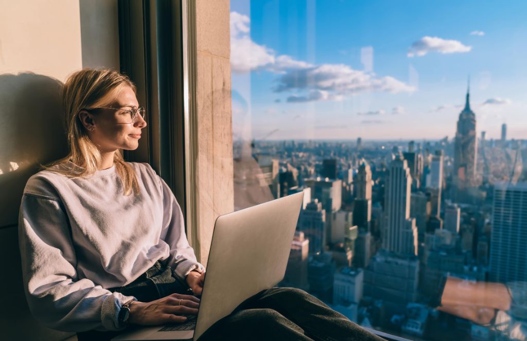 a girl on her laptop in new york - one of the best cities for solo travel in the USA