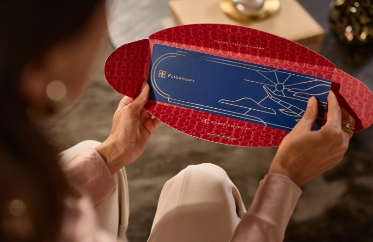 Woman holding a physical Flightgift card