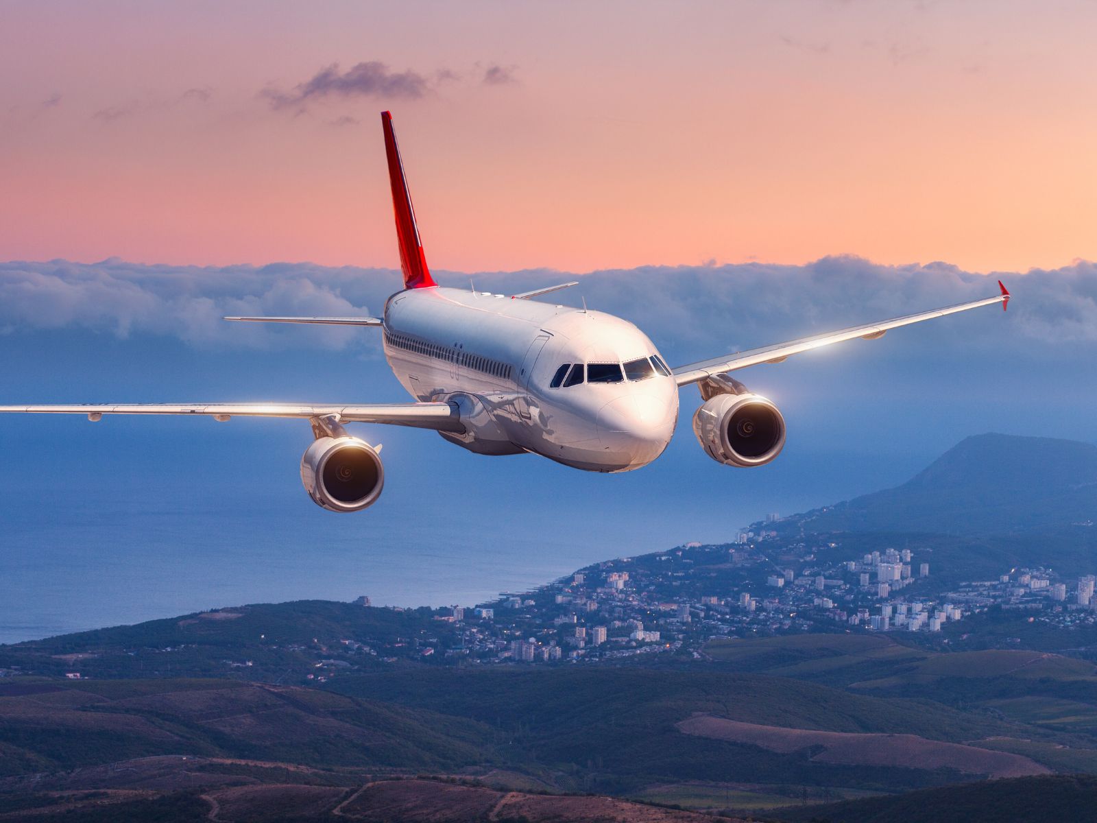 an aeroplane in the sky during sunset