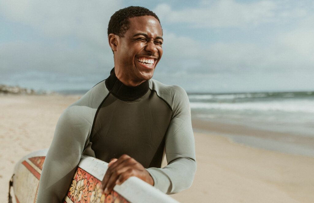 hombre a punto de surfear sonriendo
