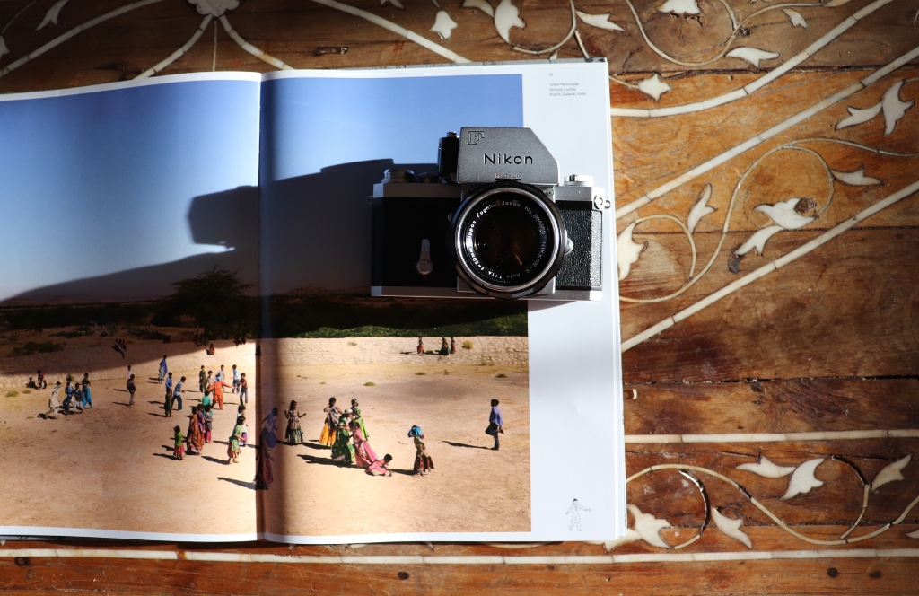 Een camera ligt op twee open pagina's in een fotoboek
