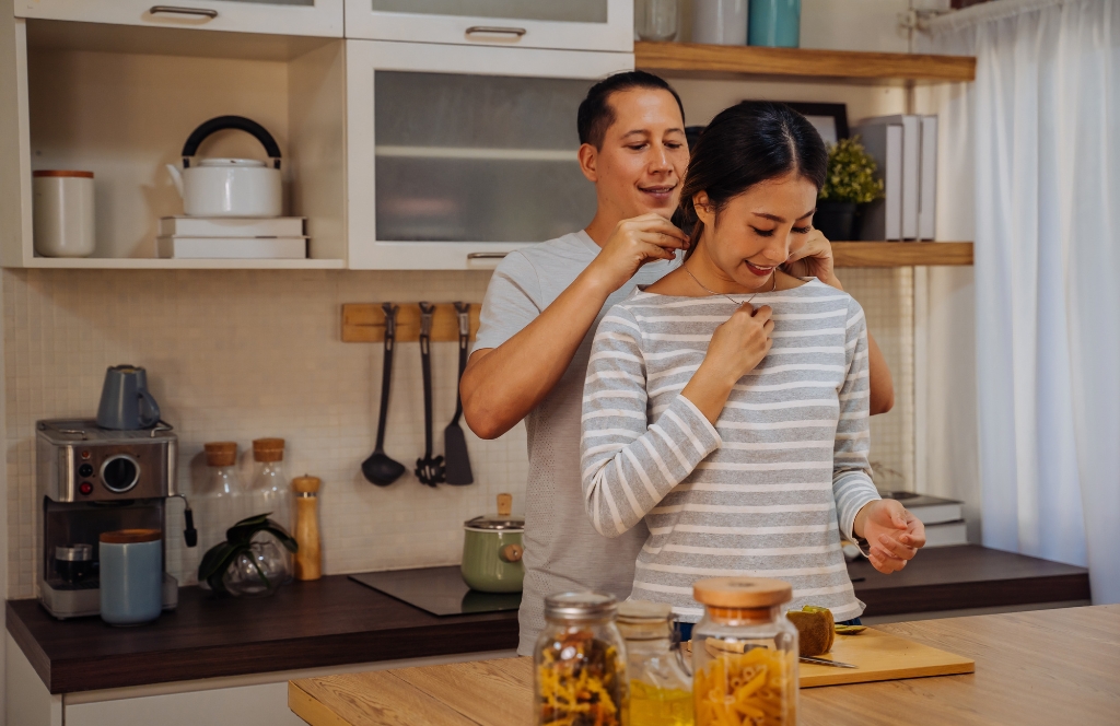 Man geeft zijn vrouw een gepersonaliseerde ketting tijdens het koken