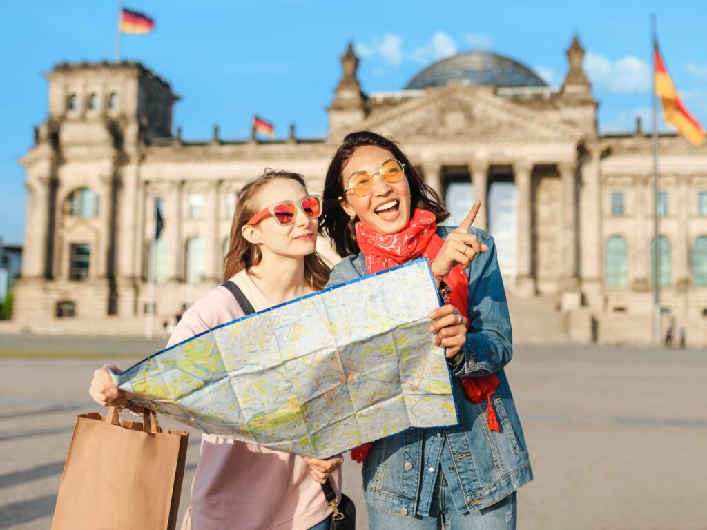 friends hold a map in berlin one of the best places to go with friends on holiday