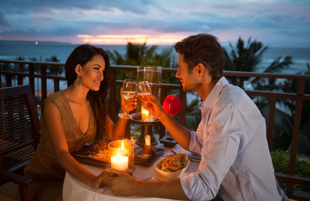 a couple enjoy dinner in one of the best luxury honeymoon destinations