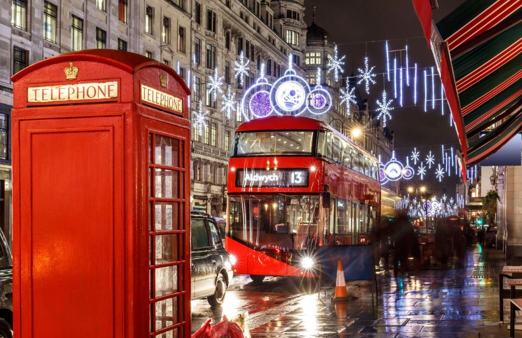 Straße in London mit weihnachtlich beleuchteter Telefonzelle und Bus