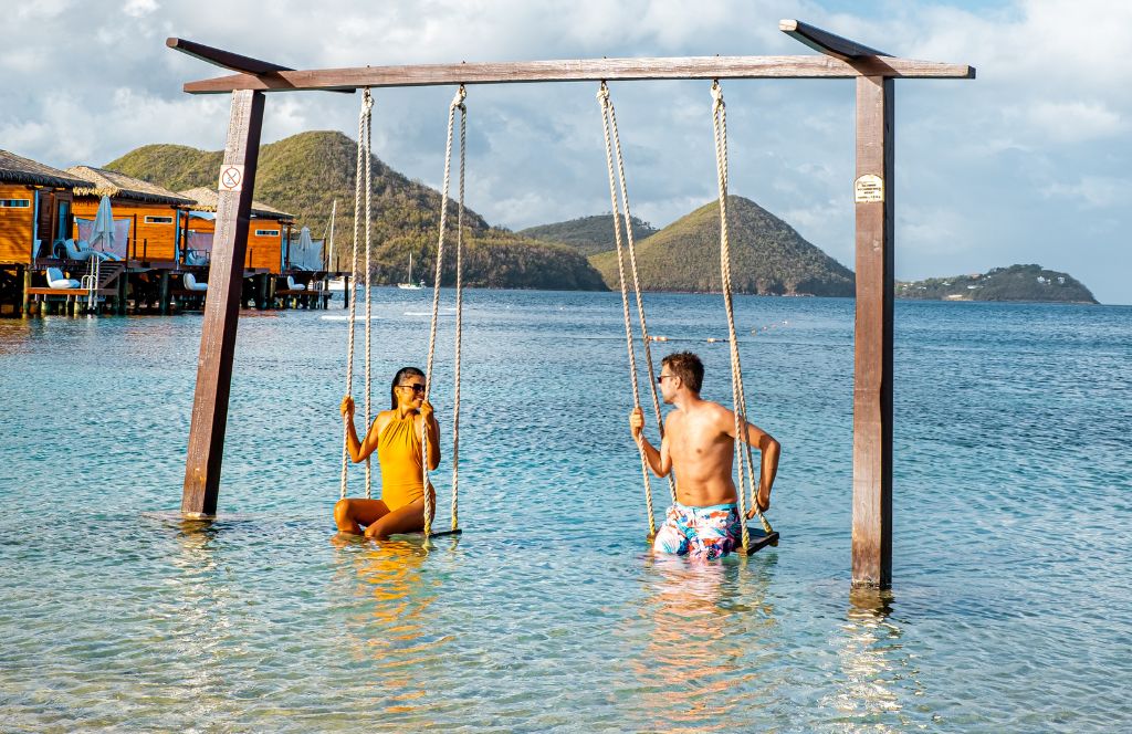 a couple on a swing in st. lucia on one of the best luxury honeymoons