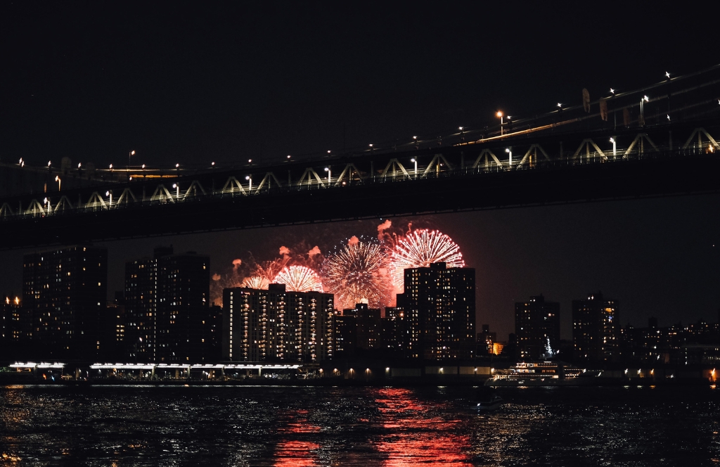 Boote auf dem Wasser vor New York und seinem Feuerwerk