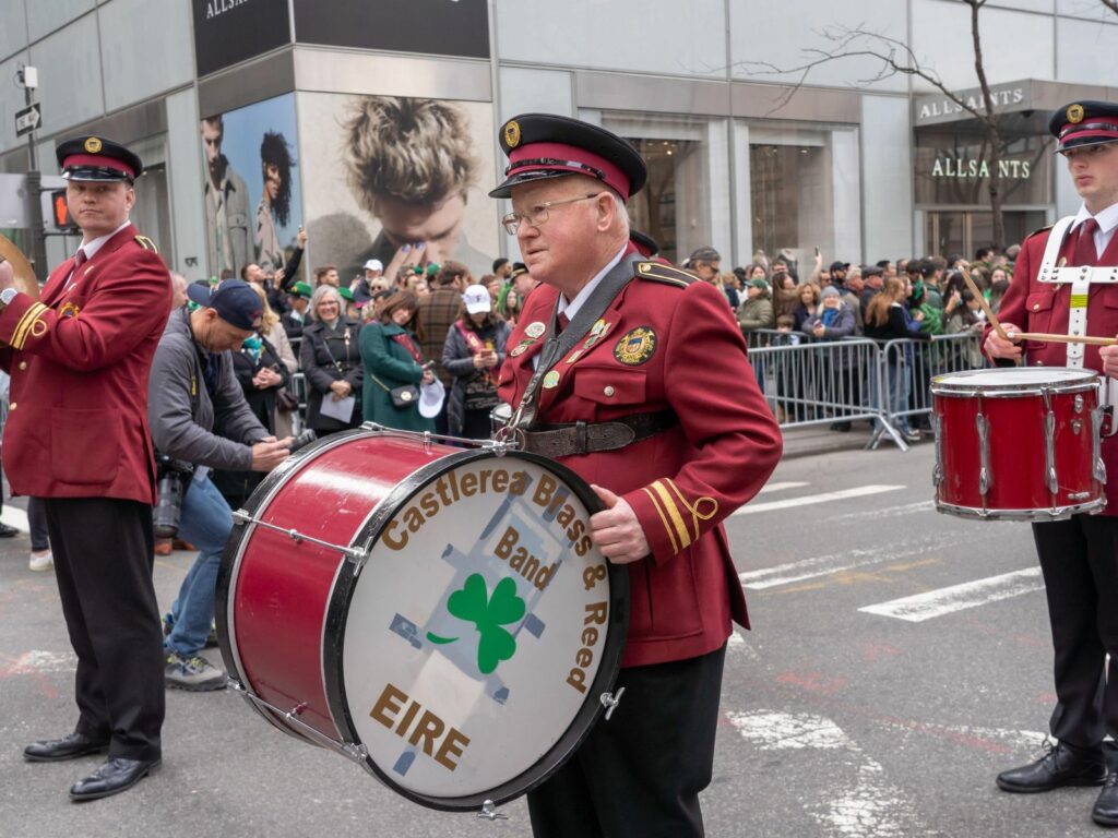 a man plays the drum in a st. patricks day parade