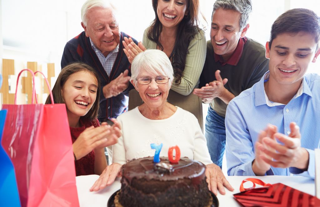 a woman opens her 70th birthday gifts