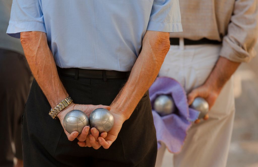 un homme tenant son nouveau set de pétanque reçu en cadeau 70 ans