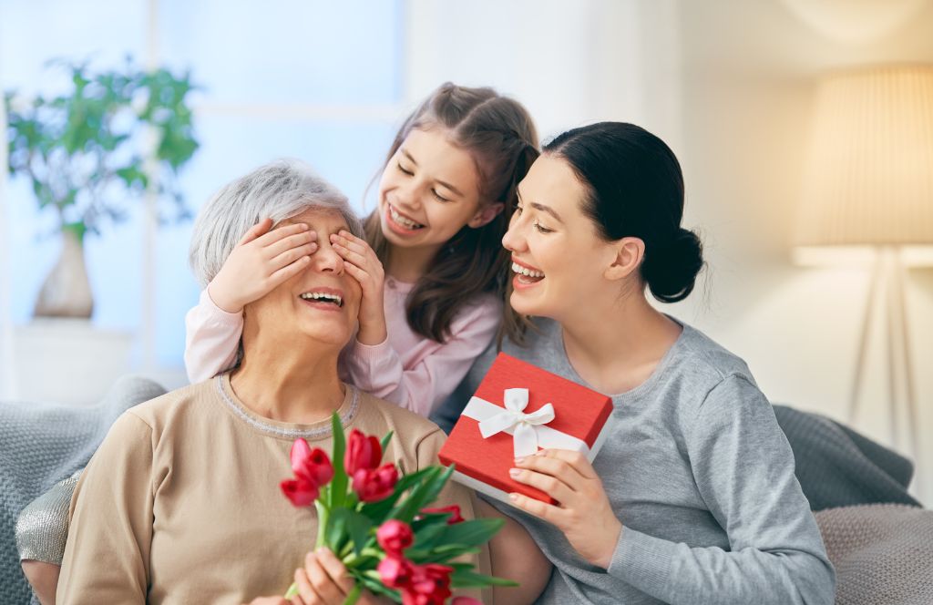 a mum and daughter give a mothers day gift for grandma