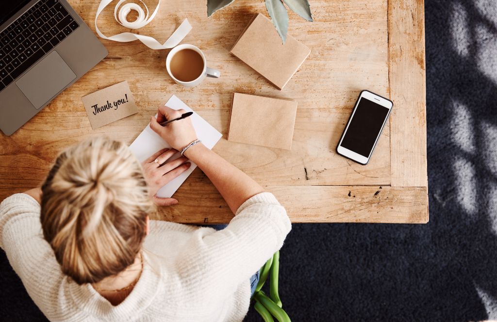 a woman writes a thank you letter for her thank you hamper