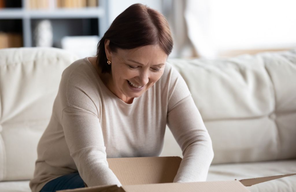 Une mère ouvrant un colis surprise en cadeau de la fête des mères à distance