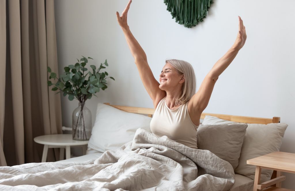 Een dame geniet van haar luxe 60e verjaardagscadeau terwijl ze wakker wordt in haar luxe beddengoed