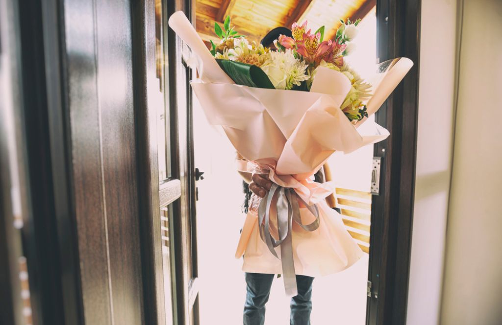 Un livreur avec un bouquet en cadeau de fête des mères à Distance