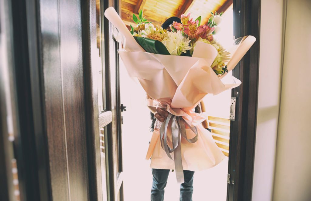Un livreur avec un bouquet en cadeau de fête des mères à Distance