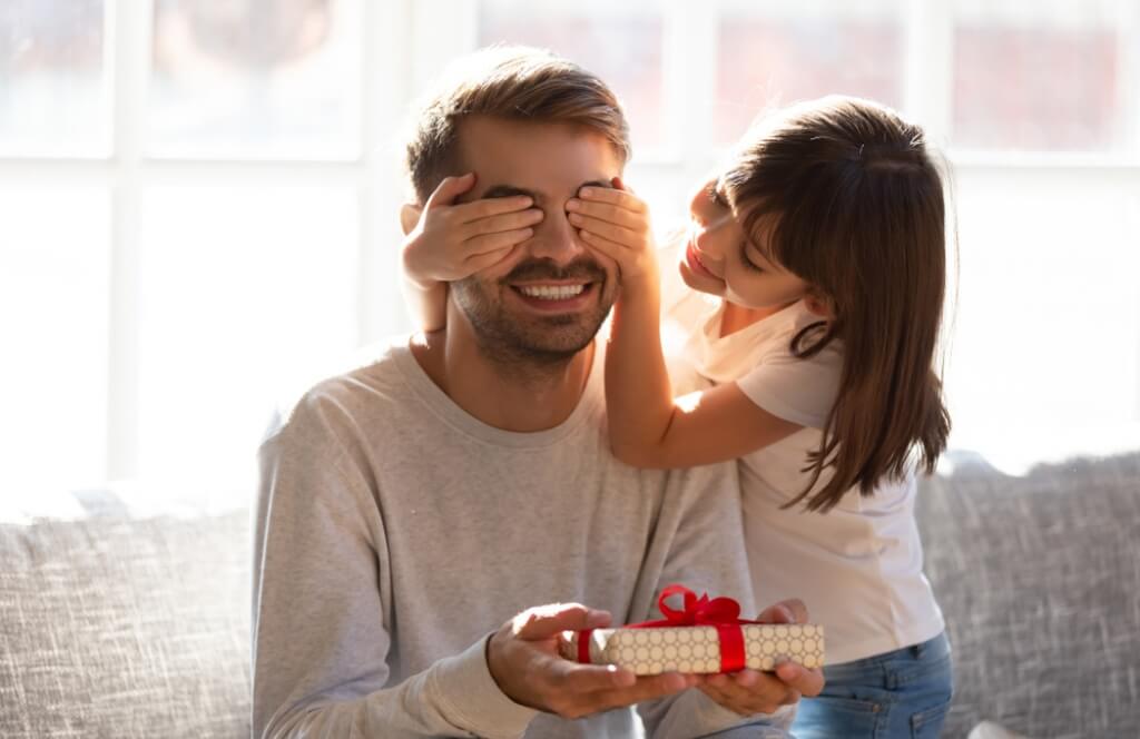 Une petite fille offrant un tshirt tel père tel fille en cadeau de la fête des pères