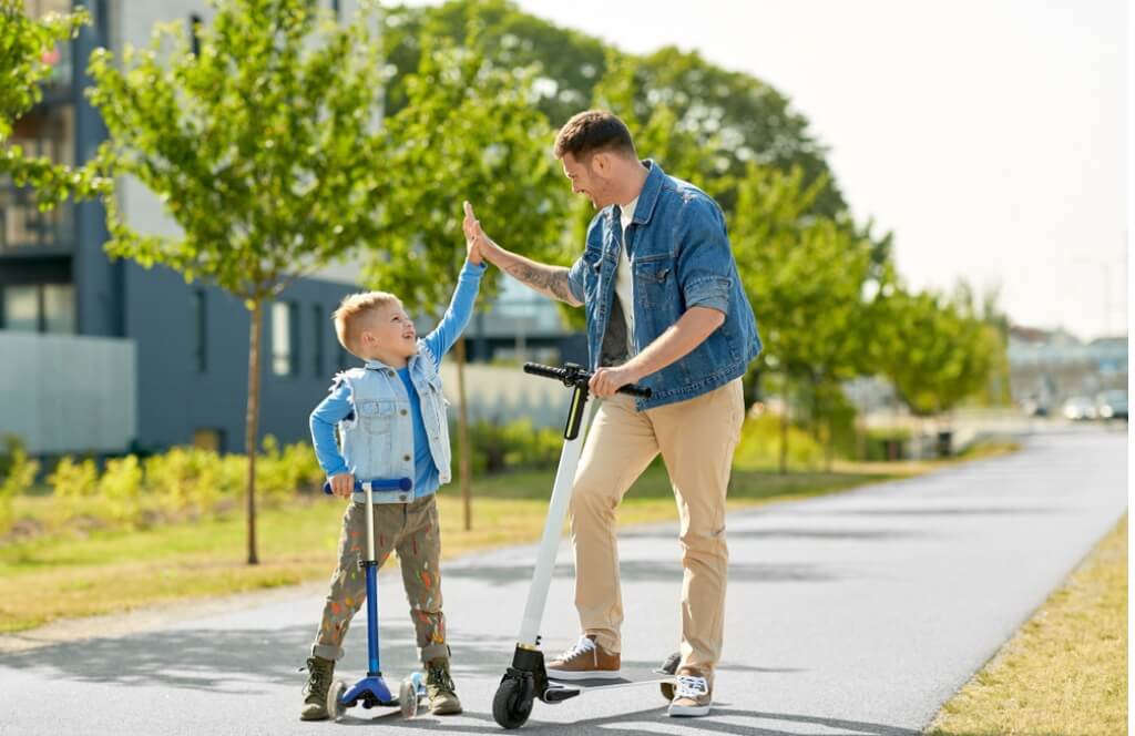 Un père qui teste avec son fils sa trottinette électrique reçu en cadeau de la fête des pères