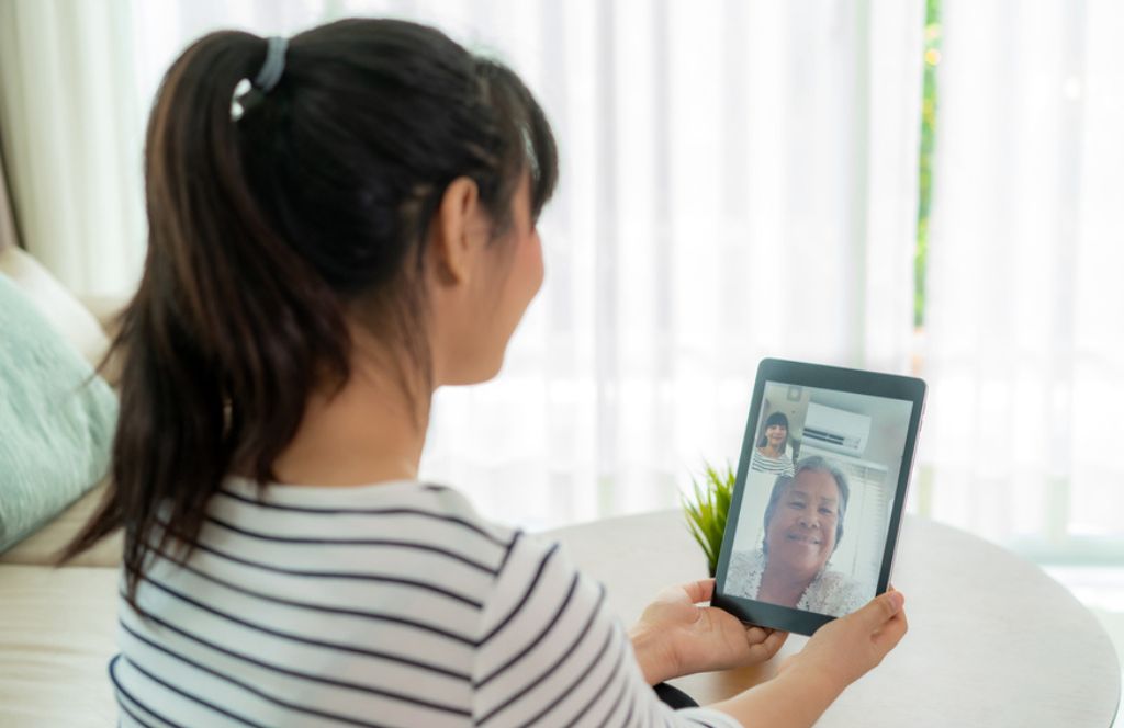 Une mère et une fille faisant une activité en ligne en cadeau de fête des mères à distance