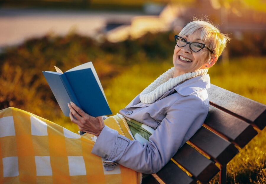 Eine Frau liest ein Buch auf einer Bank