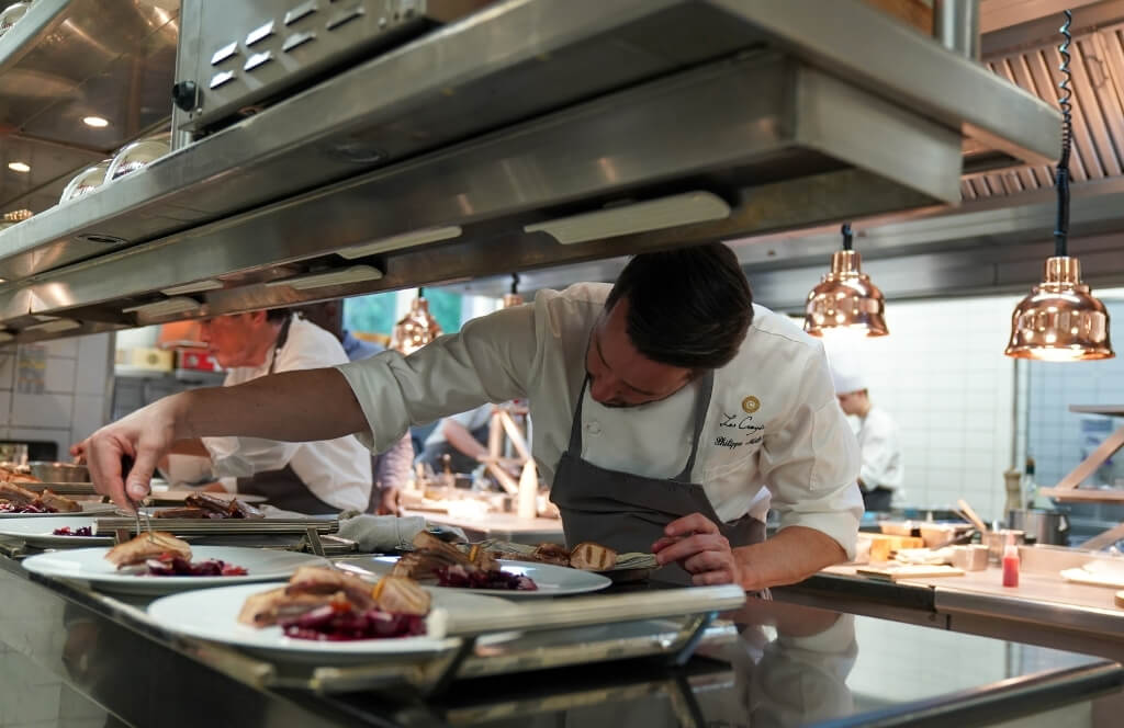 Un chef étoilé préparant des plats dans son restaurant
