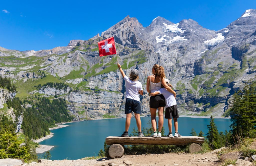 a family with a swiss flag in one of the great places to visit in switzerland