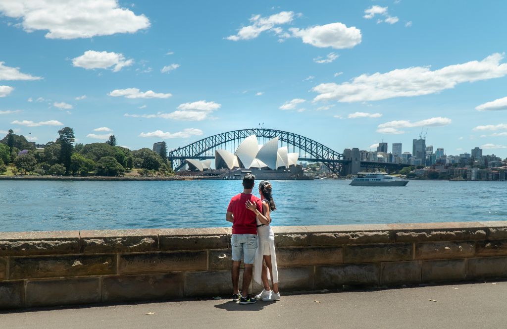 a couple look at the sydney harbour bridge on their couples holiday to aus