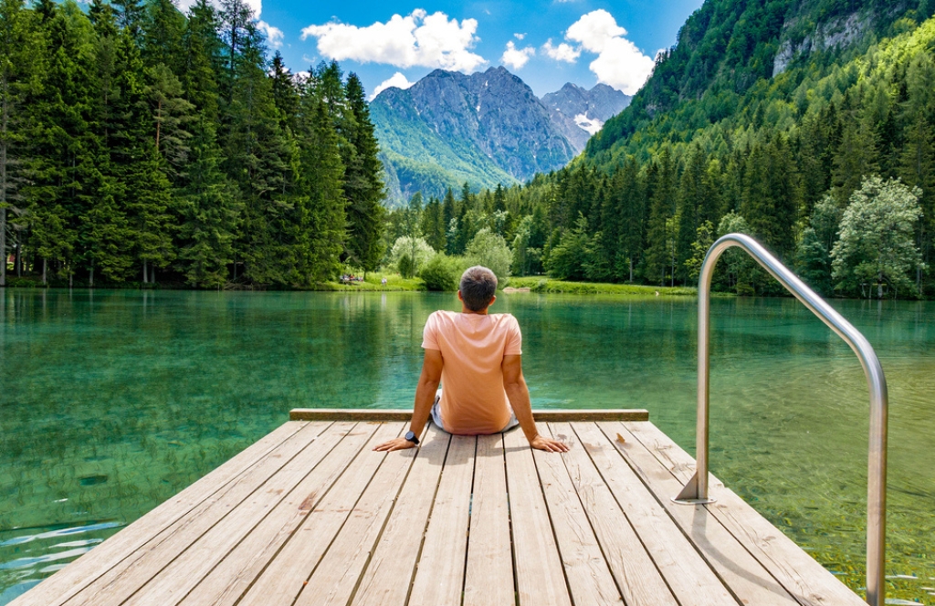 A traveler sitting by a lake in Slovenia Best places to visit in september