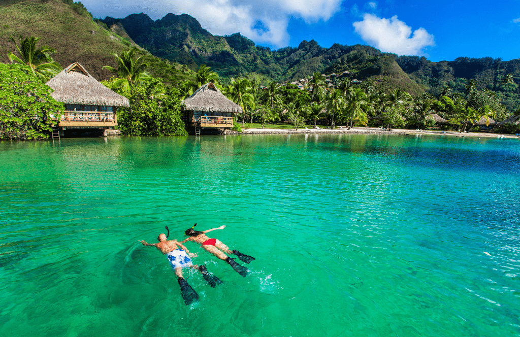 a couple swimming at one of the most expensive honeymoon destinations