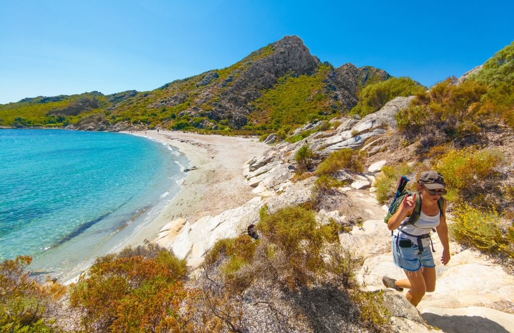 Une voyageuse randonnant en Corse où partir en mai en Europe