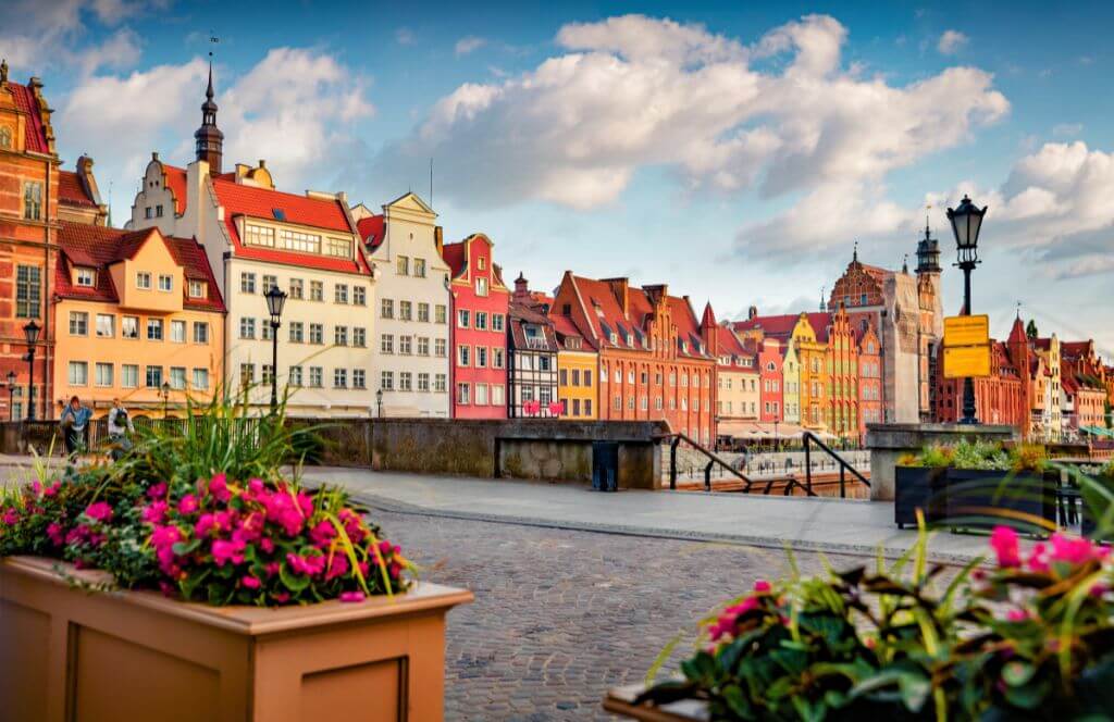 Blooming flowers on the Green Bridge with the spire of the Main Town Hall in the background.