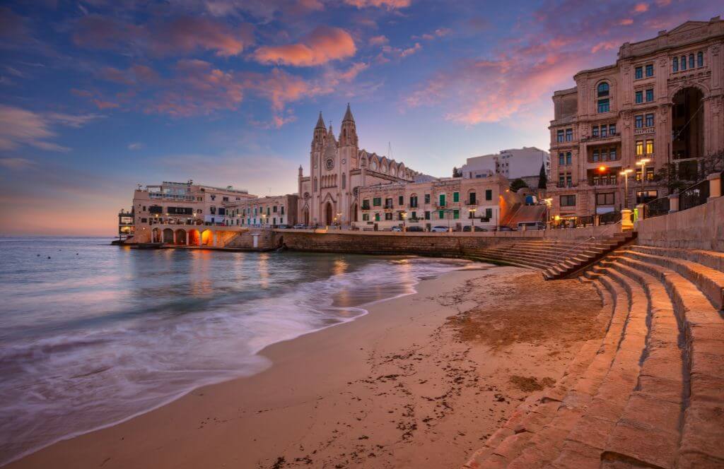 St. Julian's, Malta. This is a cityscape image of the seaside town at a beautiful sunrise.