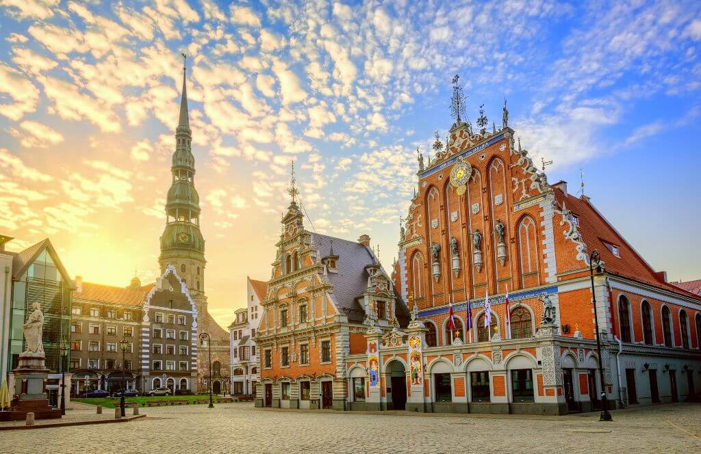 City Hall Square with House of the Blackheads and Saint Peter church in Old Town of Riga on dramatic sunrise, Latvia
