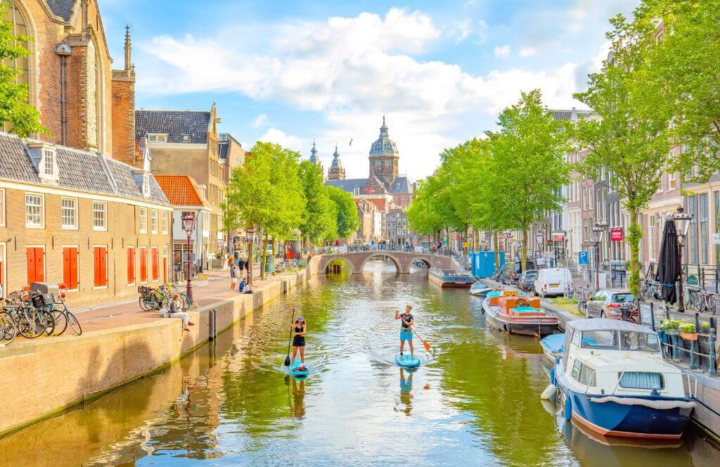 Channel in Amsterdam, Netherlands. Houses and the river Amstel. Famous European landmark. Old city landscape during sunset