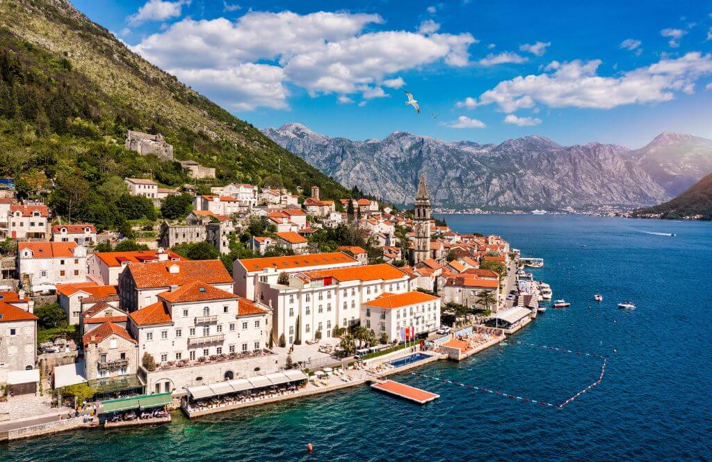 View of the historic town of Perast in the famous Bay of Kotor on a beautiful, sunny day with a blue sky and clouds in summer, Montenegro. The historic city of Perast, located at the Bay of Kotor, in Montenegro, in the summer.