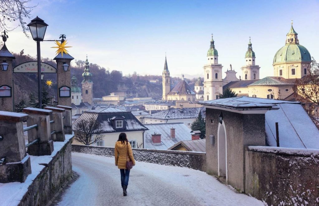 Vista panorámica de Salzburgo en invierno con la fortaleza de Hohensalzburg y techos nevados