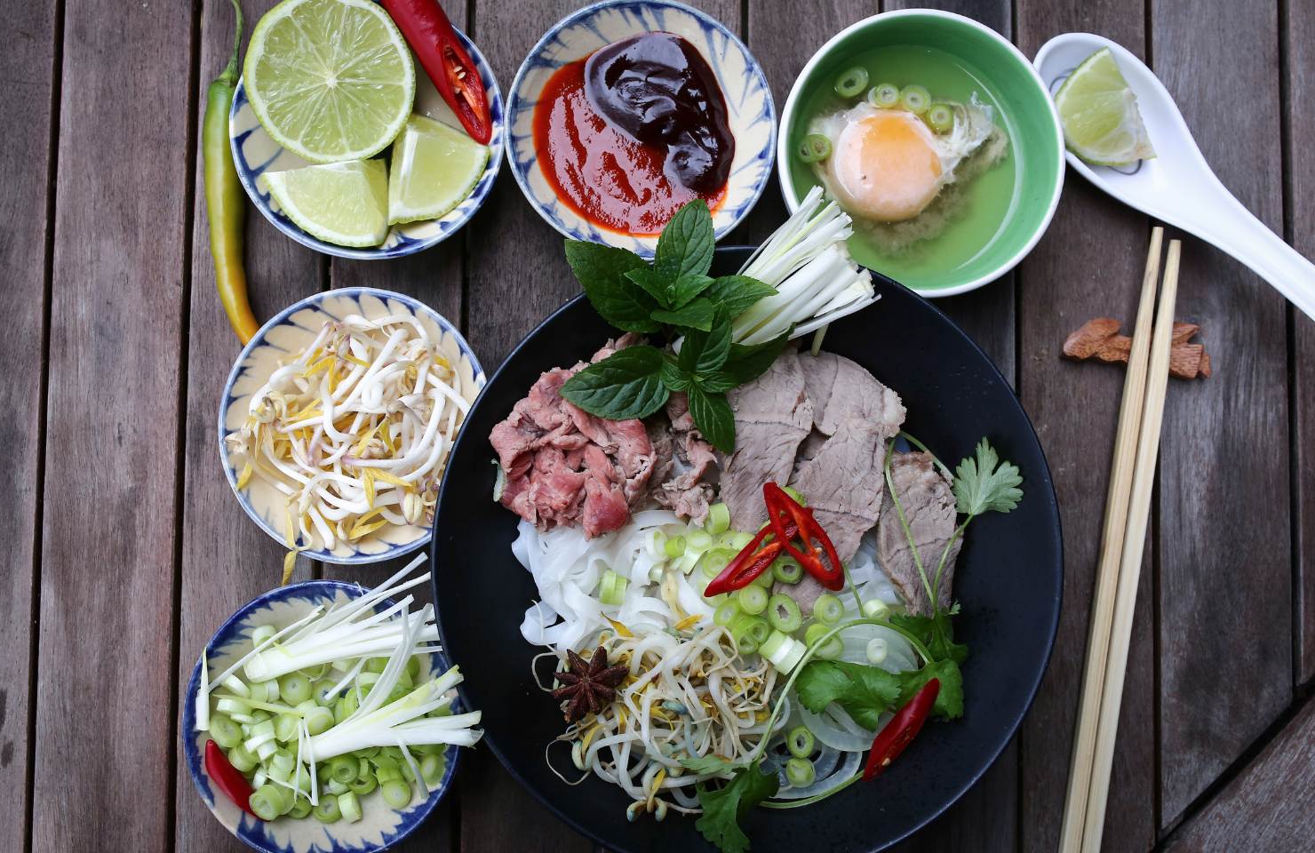 pho vietnam with condiments and chopsticks